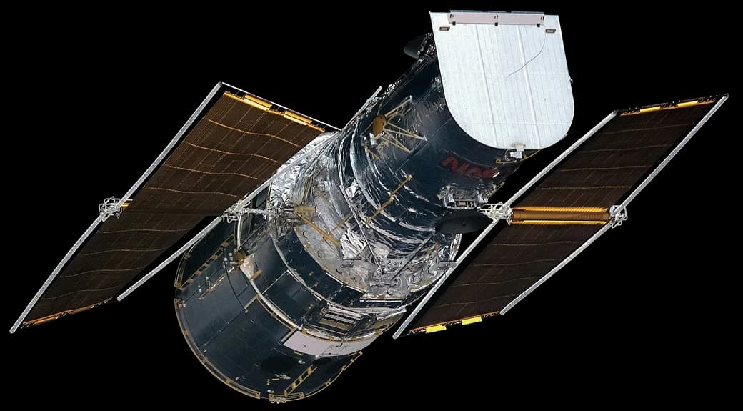 Image of the NASA Hubble Space Telescope in space, showing the telescope and the stars.